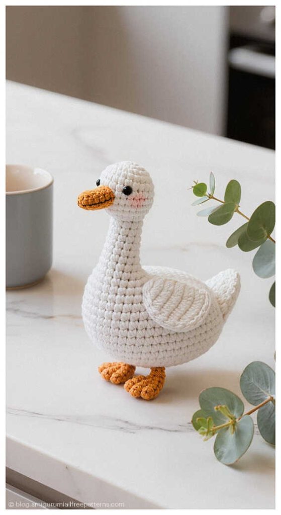 Cute amigurumi goose crochet toy standing on a kitchen counter, handmade crochet goose gift