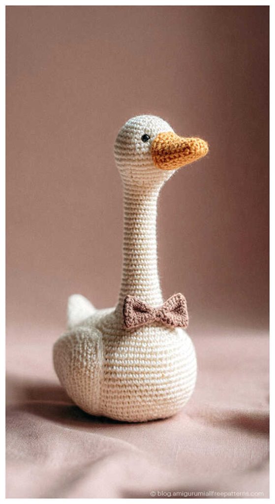 Amigurumi goose crochet toy with a bow tie on a soft background, cute crochet goose decor