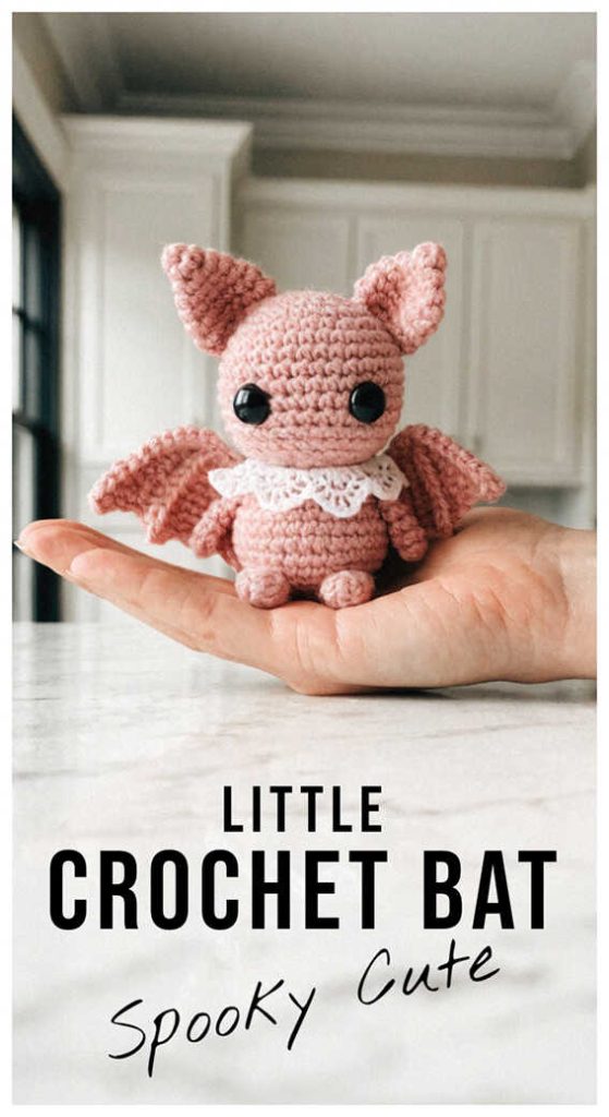 Small pink amigurumi bat sitting in a hand, adorable crochet bat plush toy