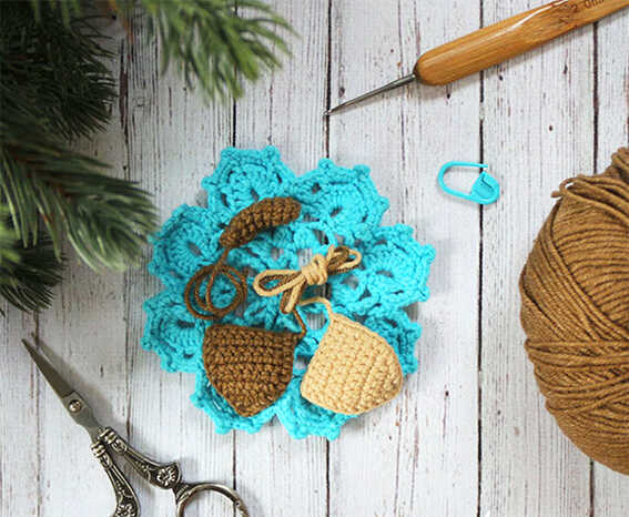 Crochet puppy ears and tail pieces with yarn and tools on wooden surface, amigurumi dog parts for free crochet pattern