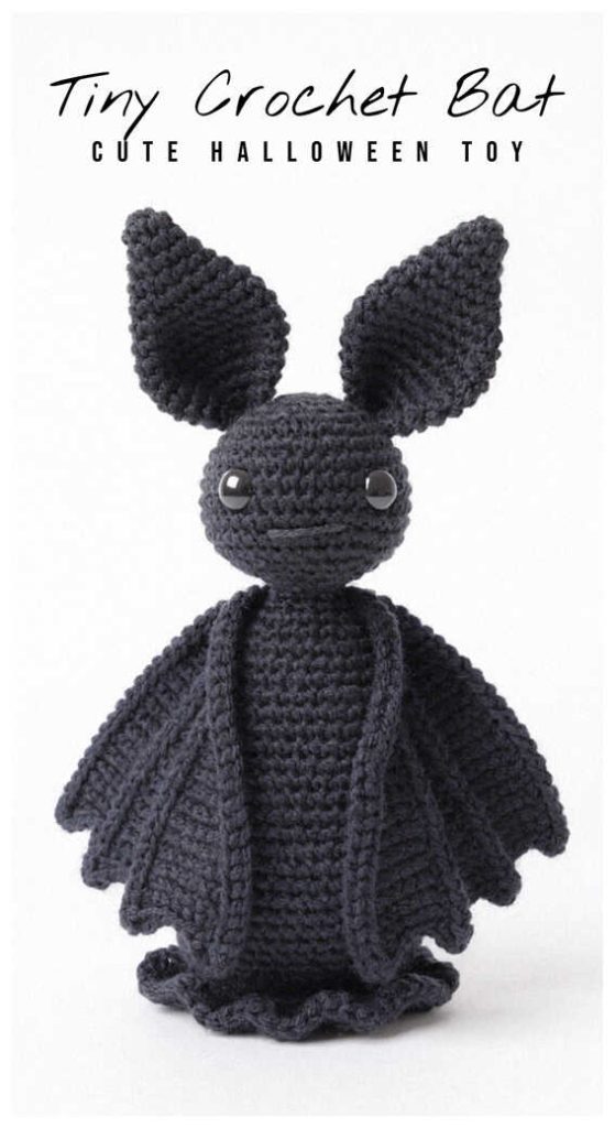 Tiny black amigurumi bat with long wings standing upright, crochet bat plush toy