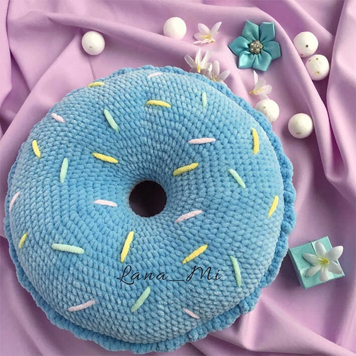 Blue amigurumi donut pillow with colorful sprinkles on soft fabric, free crochet donut cushion pattern